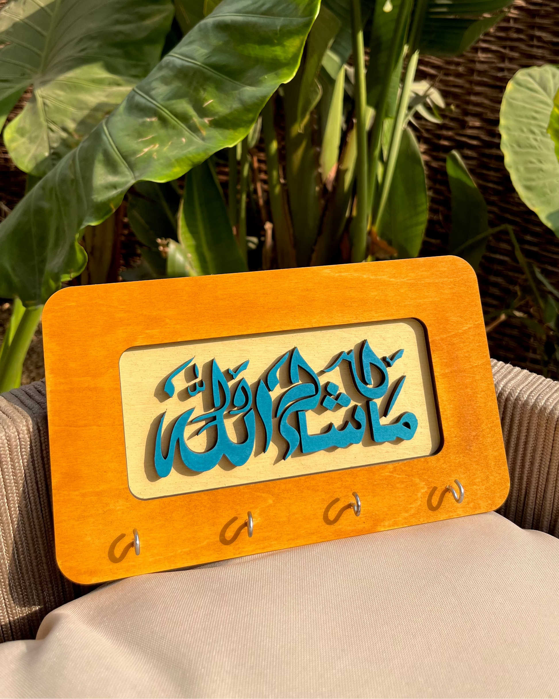 Wooden plaque with Arabic calligraphy on a plant background