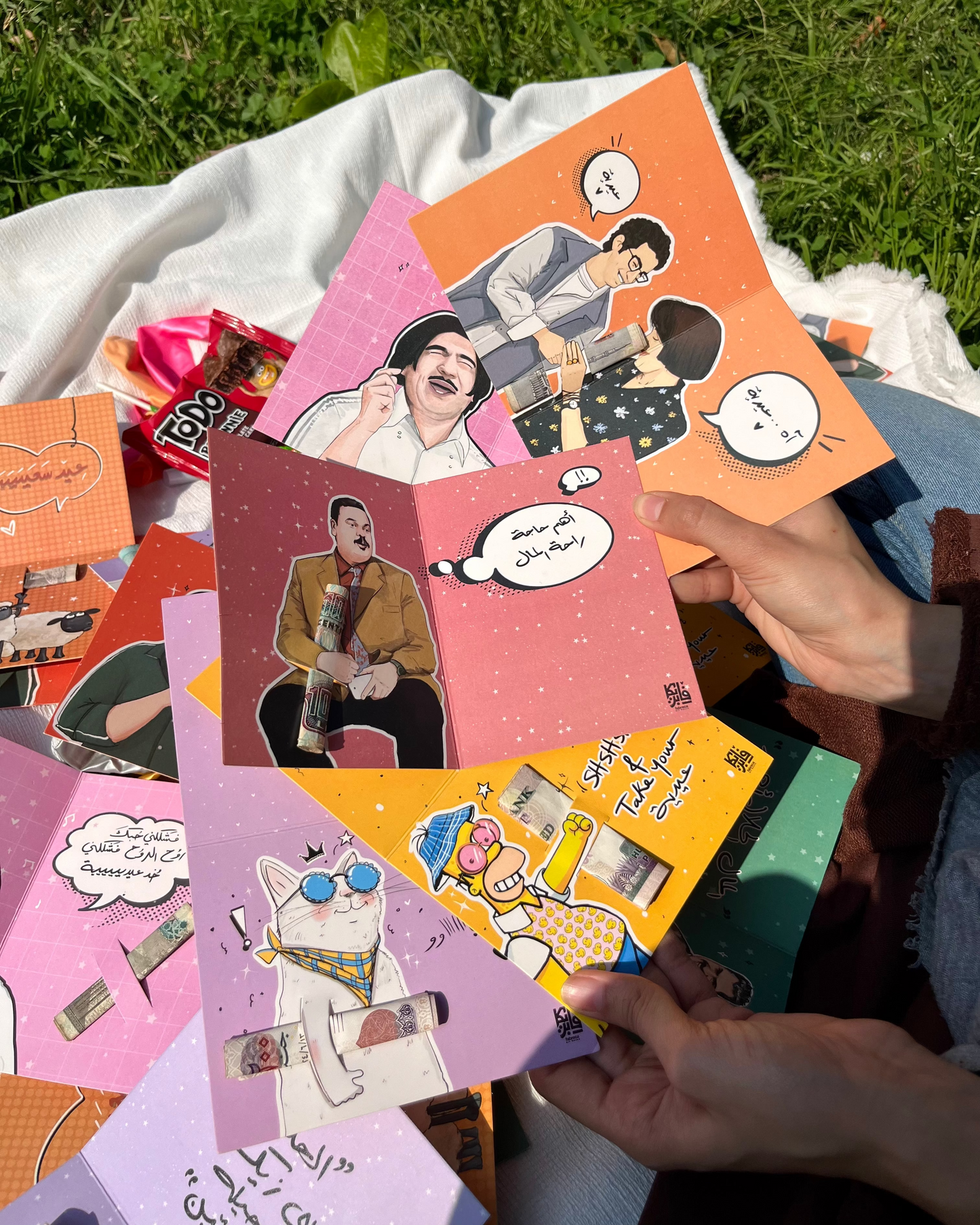 Collection of colorful greeting cards with illustrations on a grassy background