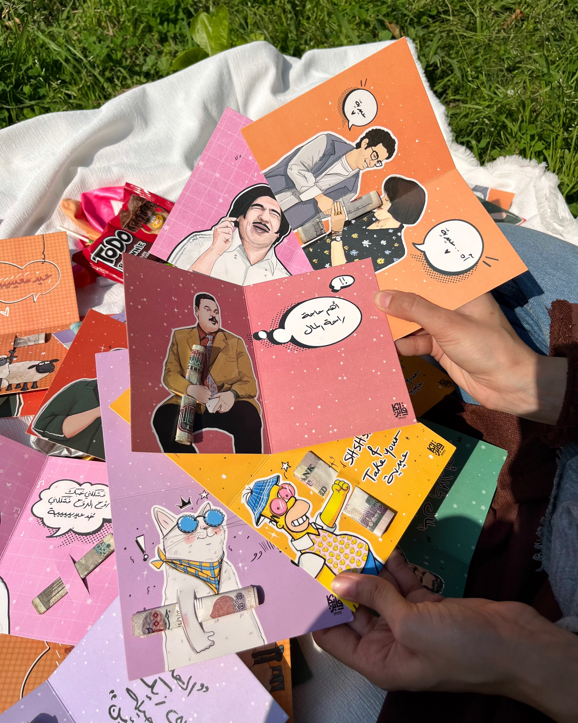 Collection of colorful greeting cards with illustrations on a grassy background